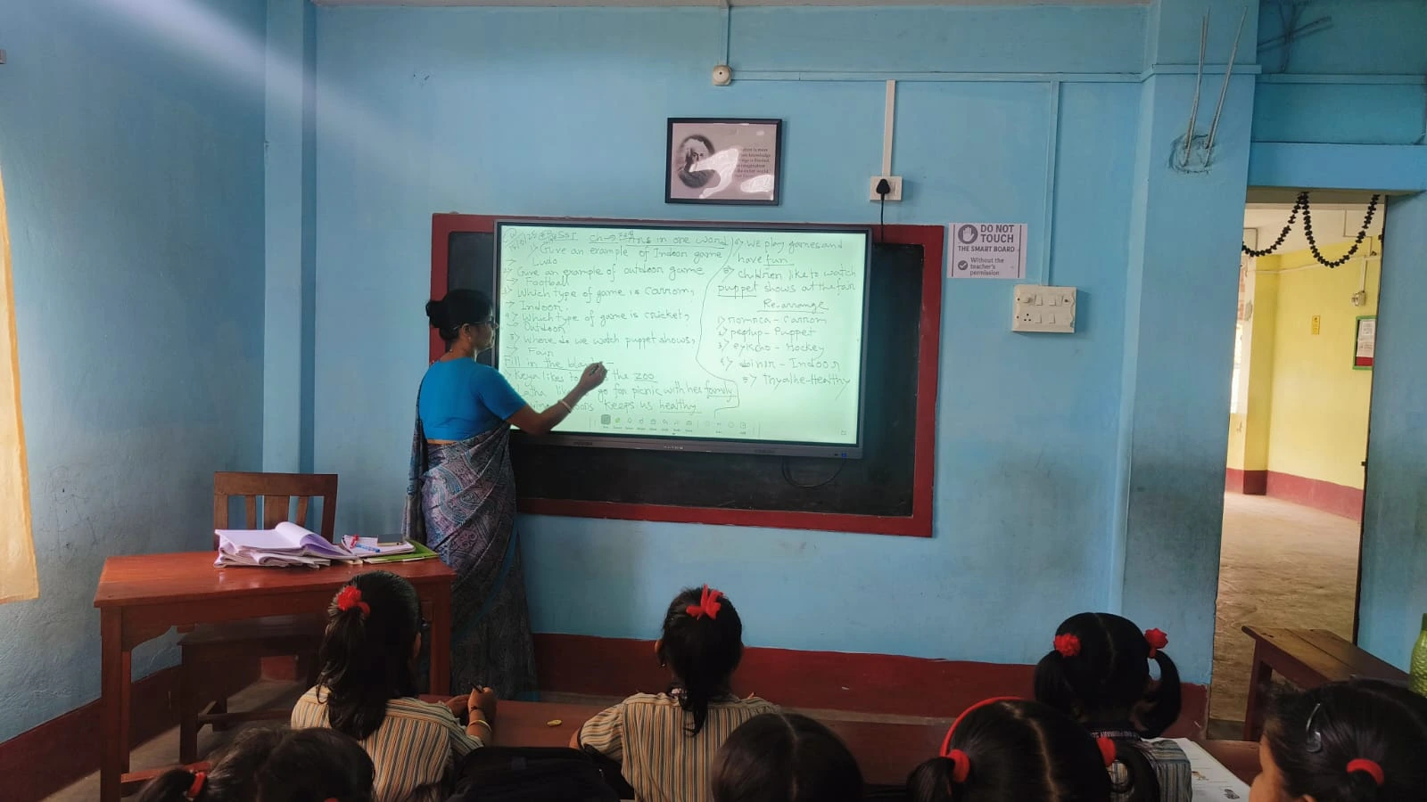 Teacher explaining a lesson using a classroom smart board
